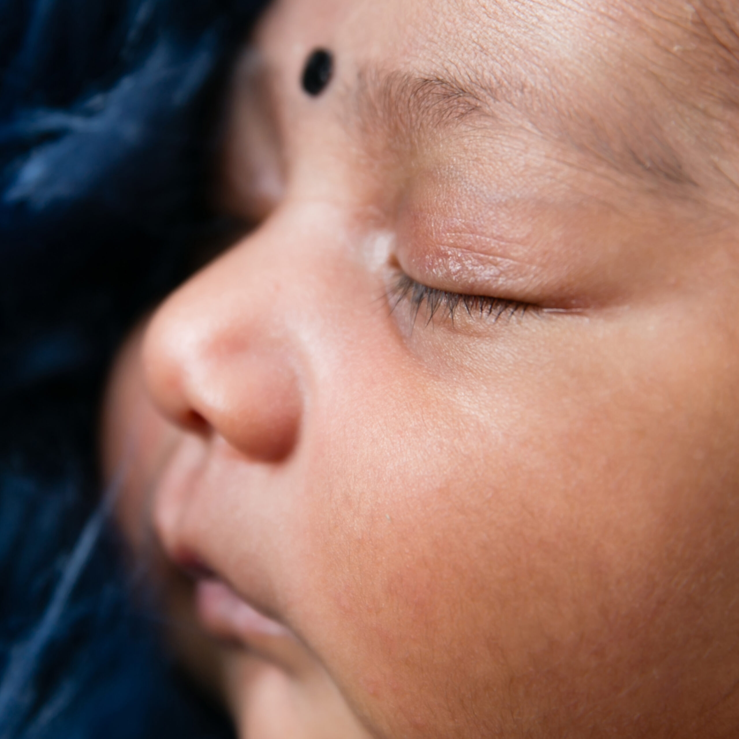 Close-up newborn photography of lashes, nose and lips of a baby girl