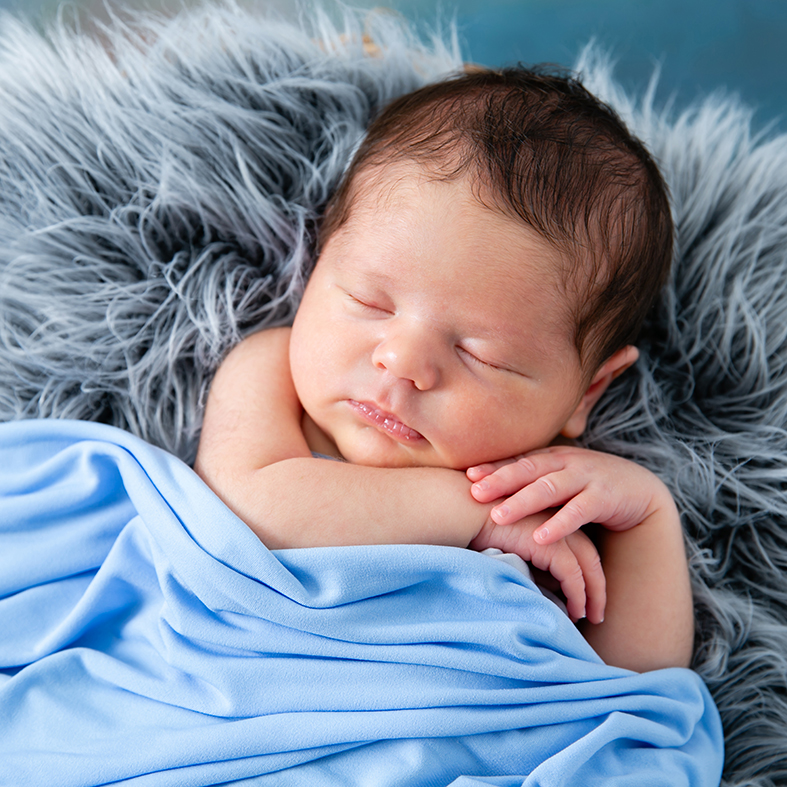 Newborn photography close-up of a baby boy featuring his tiny fingers.